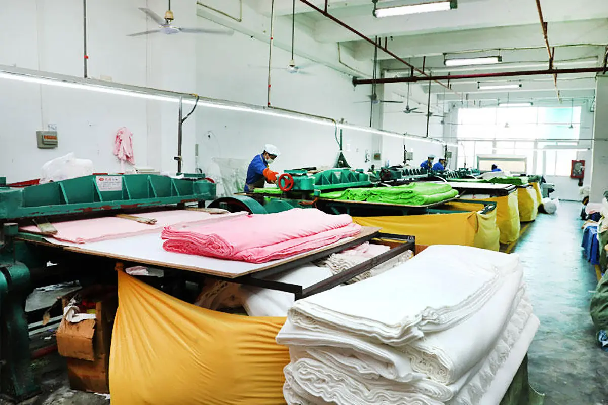 Plush fabric cutting workshop with layered fabric prepared for production