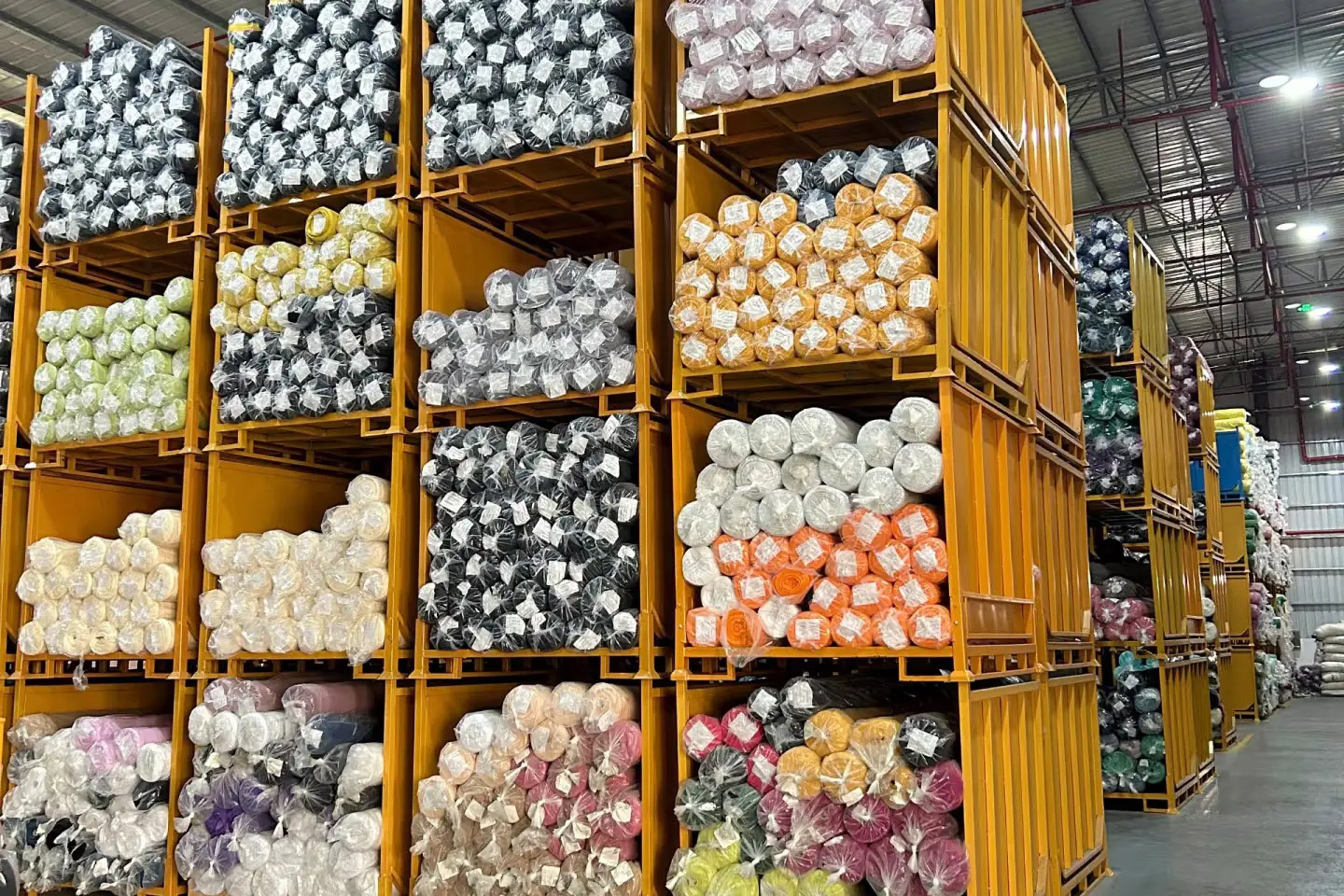 Colorful plush fabric rolls organized in a material warehouse