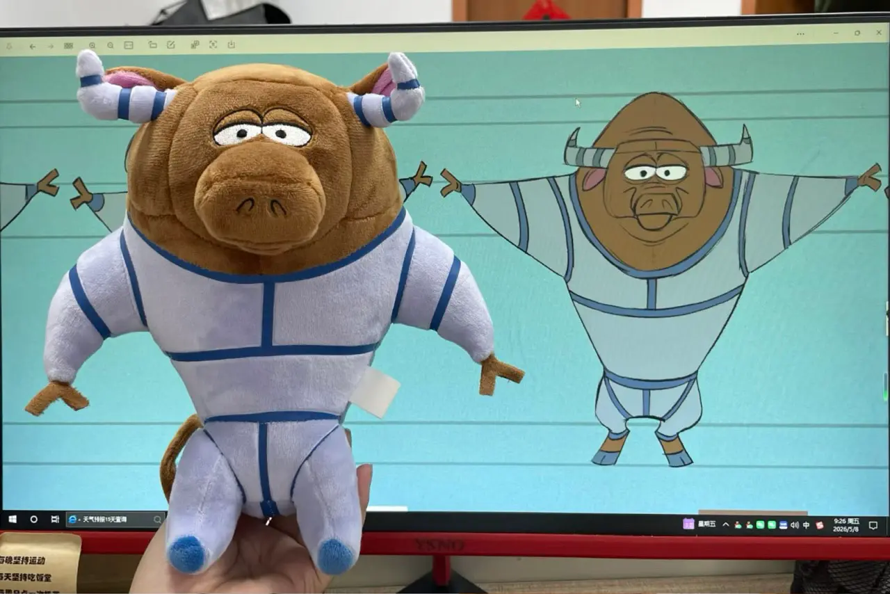 bull sports mascot plush in white blue uniform beside artwork