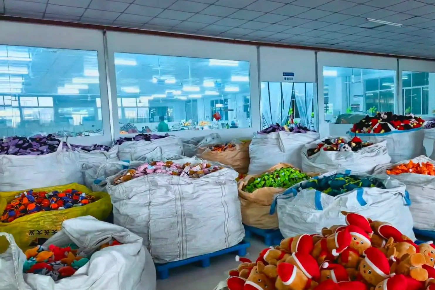 Bulk mascot plush toys sorted in factory bags for repeat production review