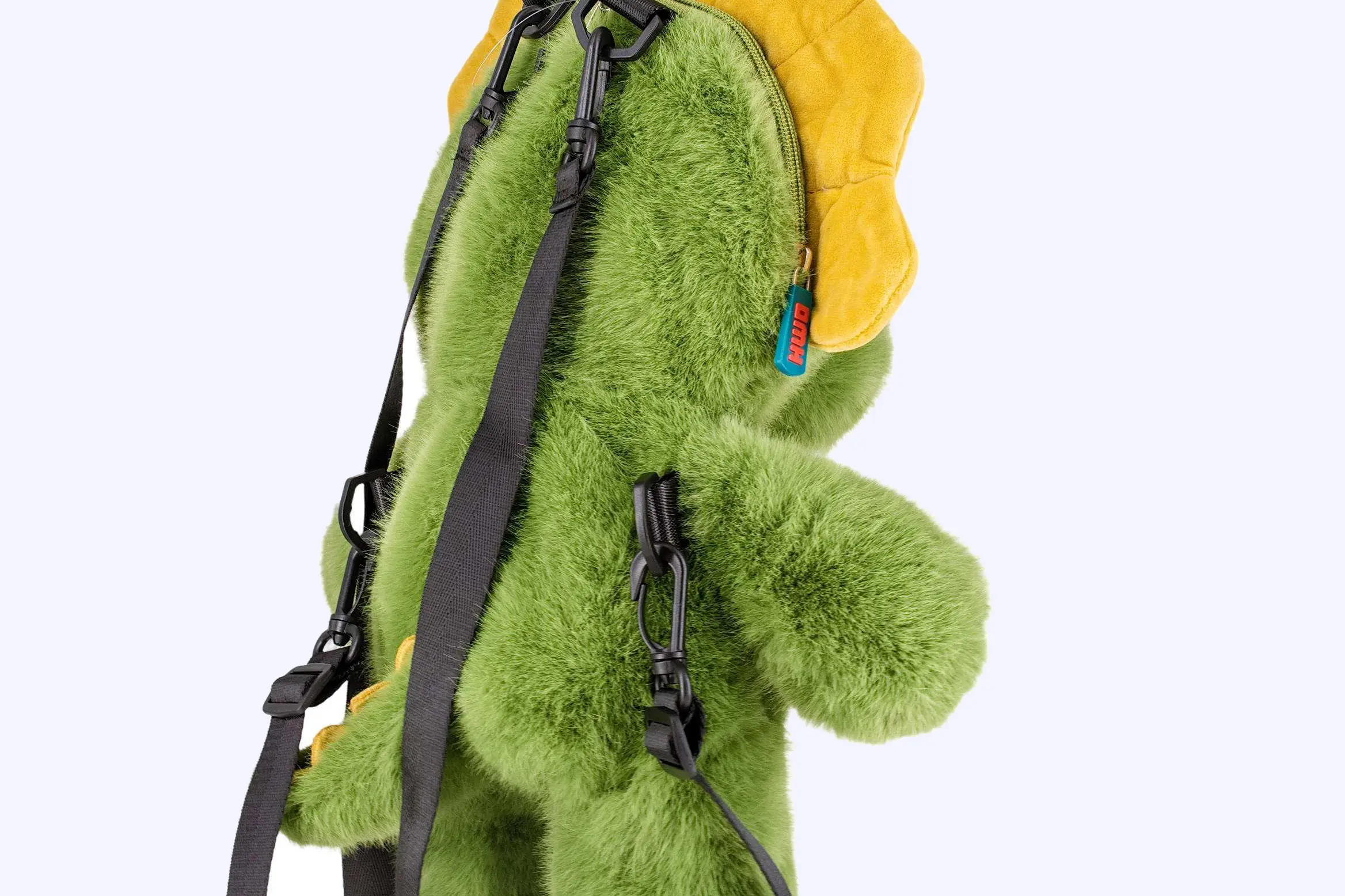 Green dinosaur plush bag back view with adjustable black straps and plastic buckles