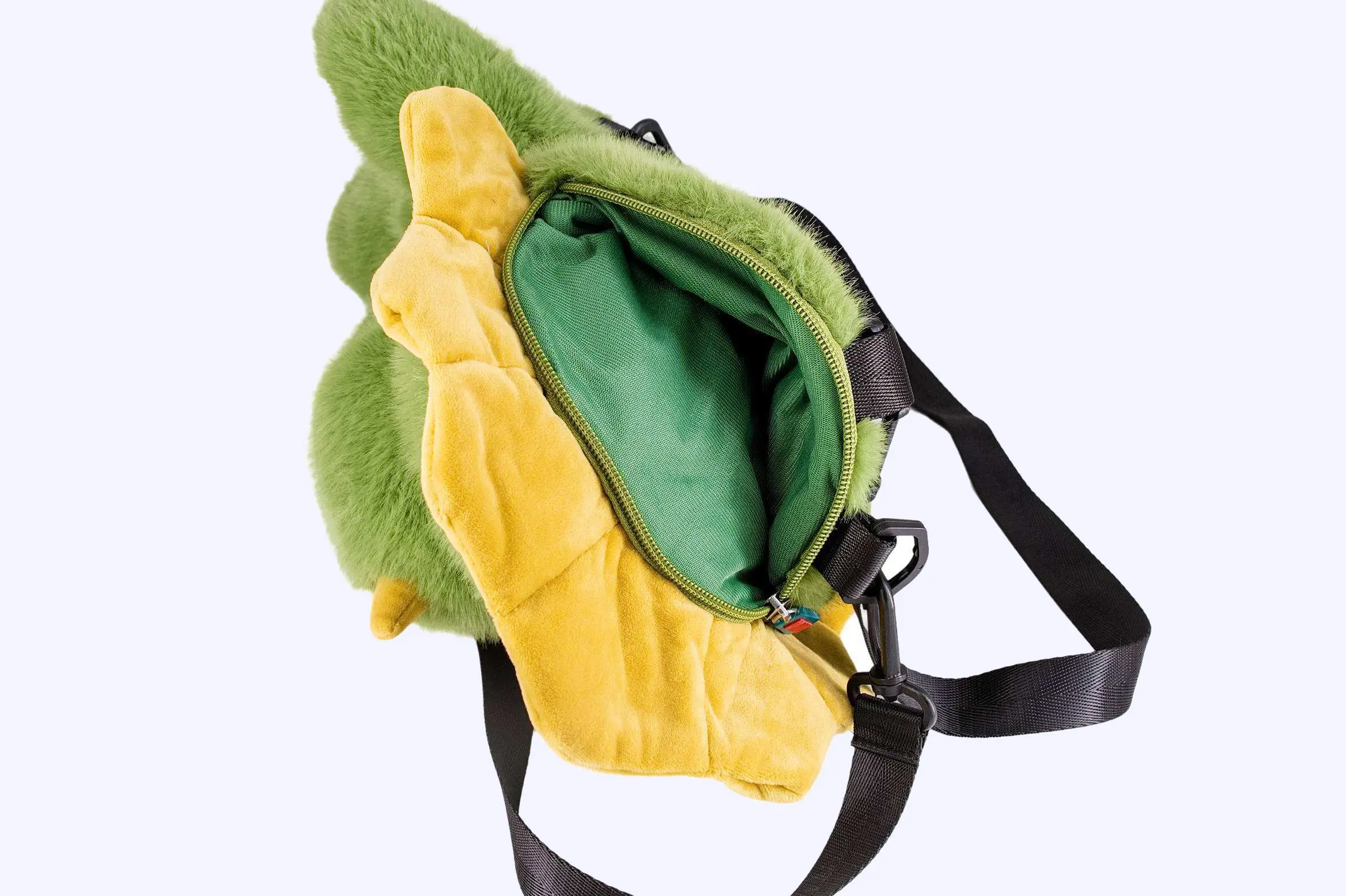 Green dinosaur plush bag opened to show zipper lining and usable inner space