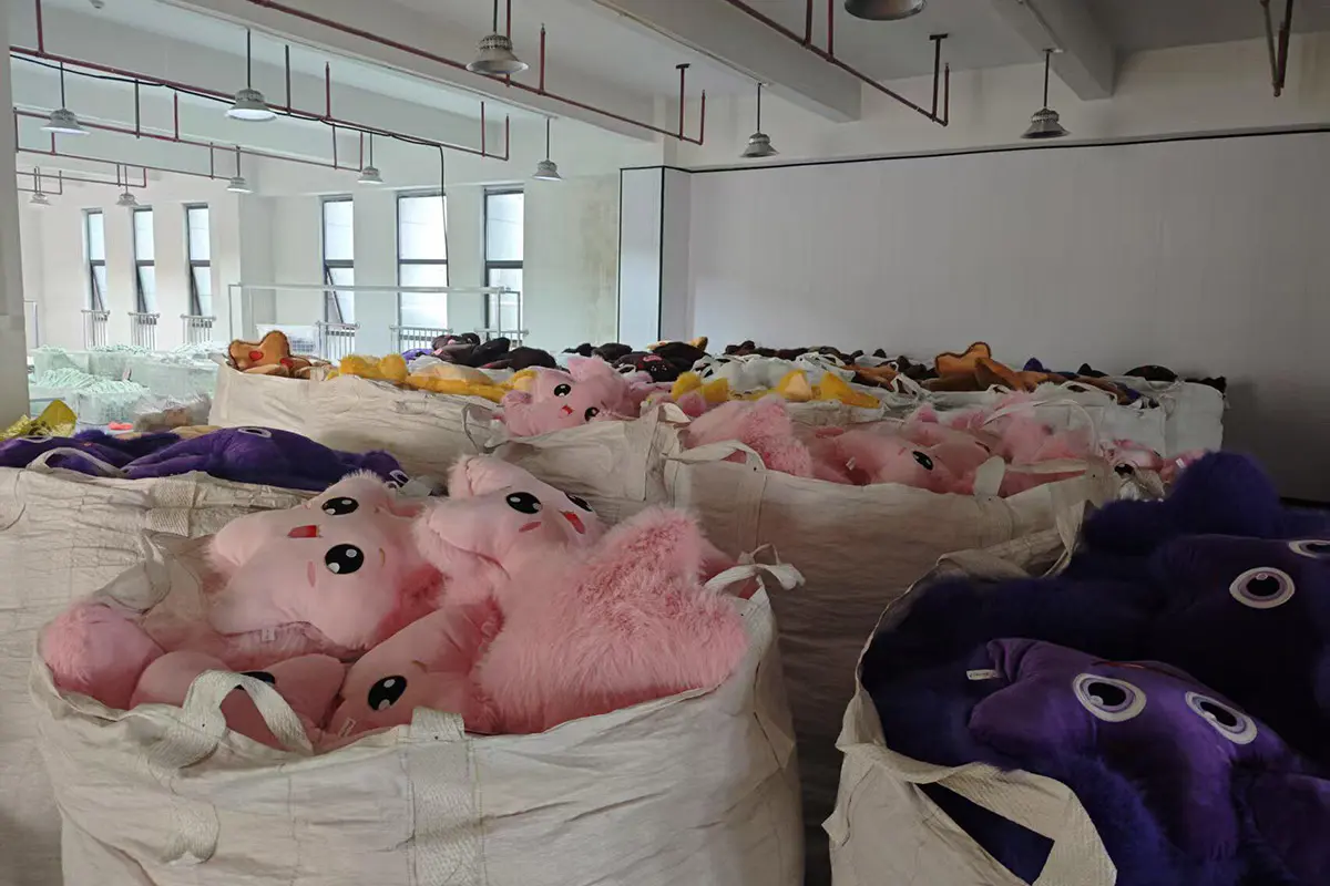 Bulk plush pillows stored in large bags inside the factory workshop
