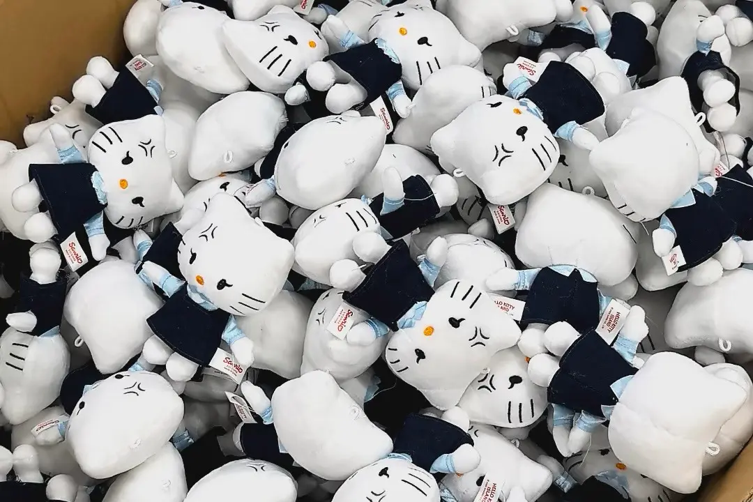 Bulk white cat plush toys with labels ready for production order review