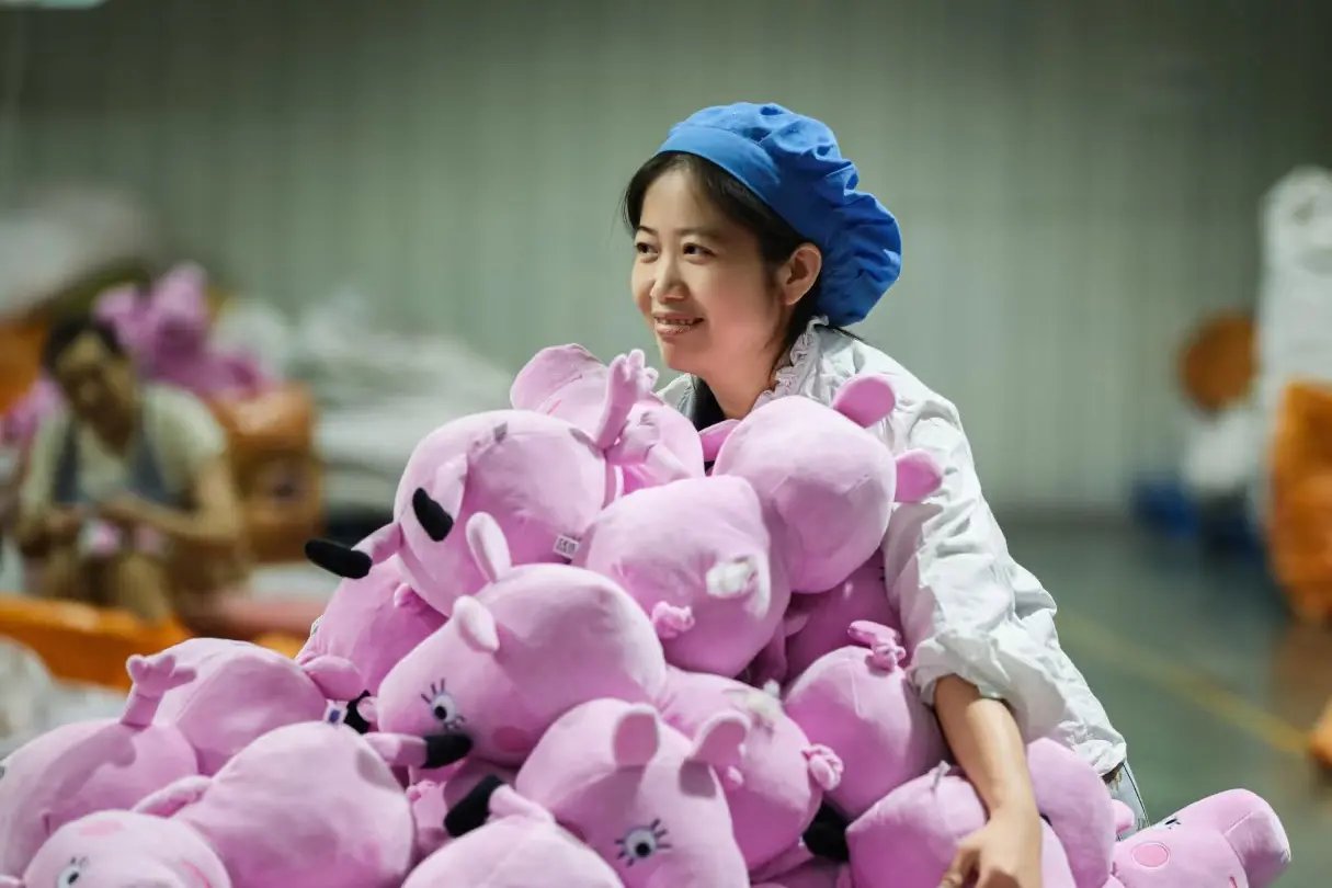 Worker sorting finished pink plush toys during bulk production