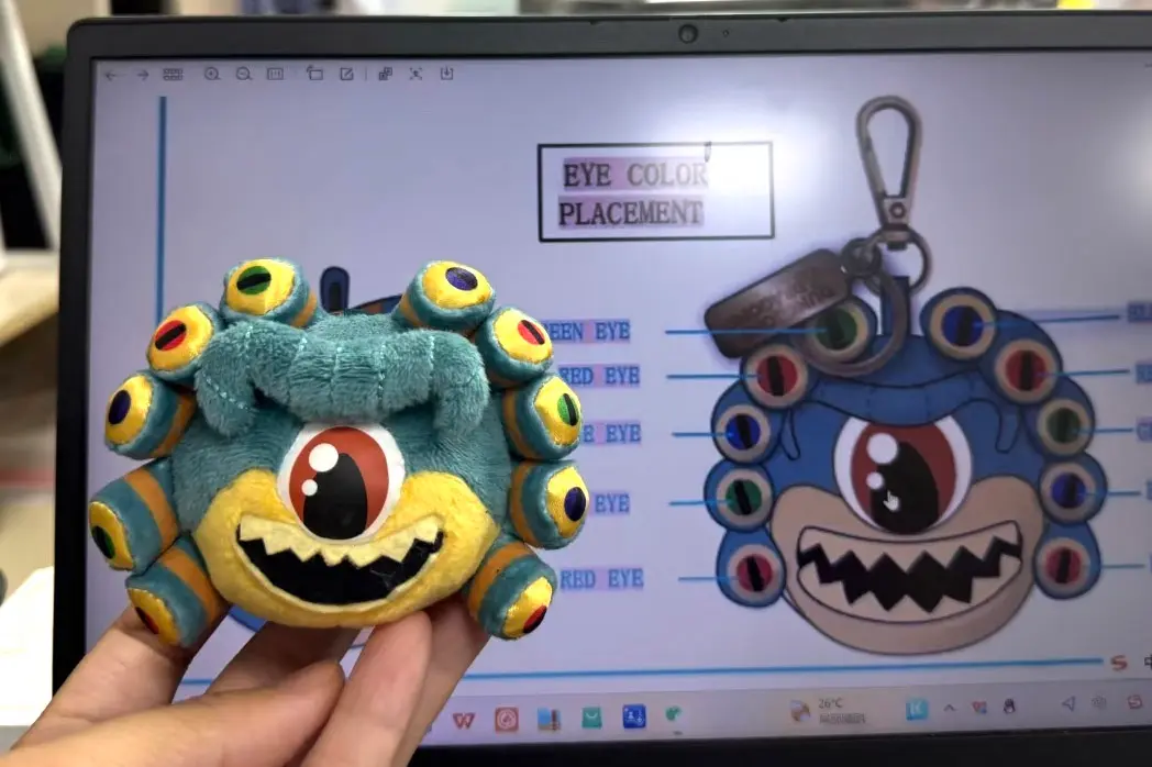 Small monster keychain plush sample checked against eye color placement artwork