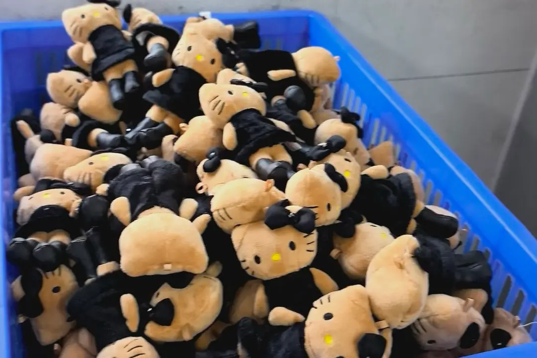 Mini mascot plush toys piled in a blue production bin before packing