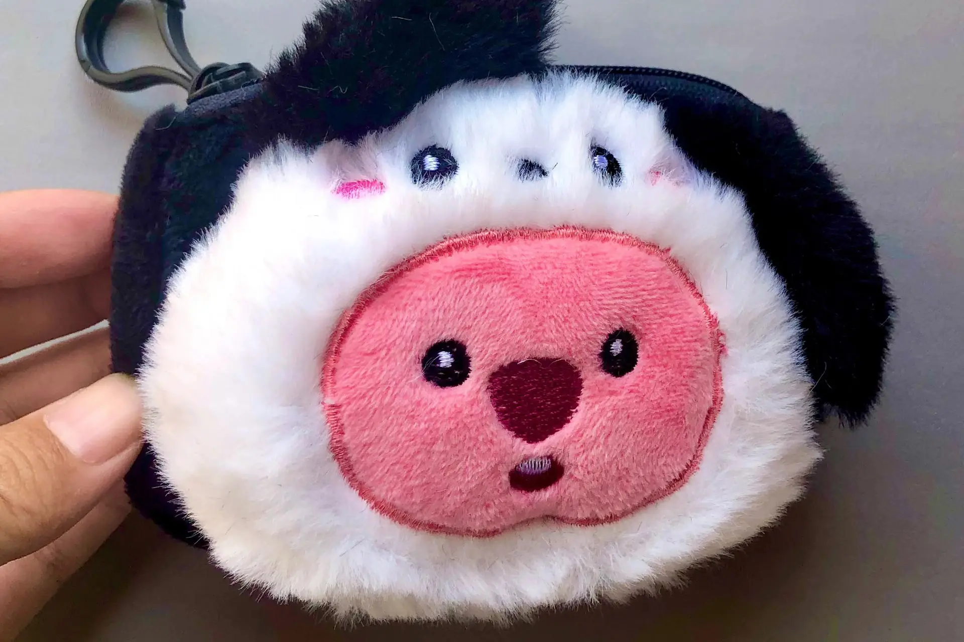 Close up of penguin plush coin purse with embroidered face details