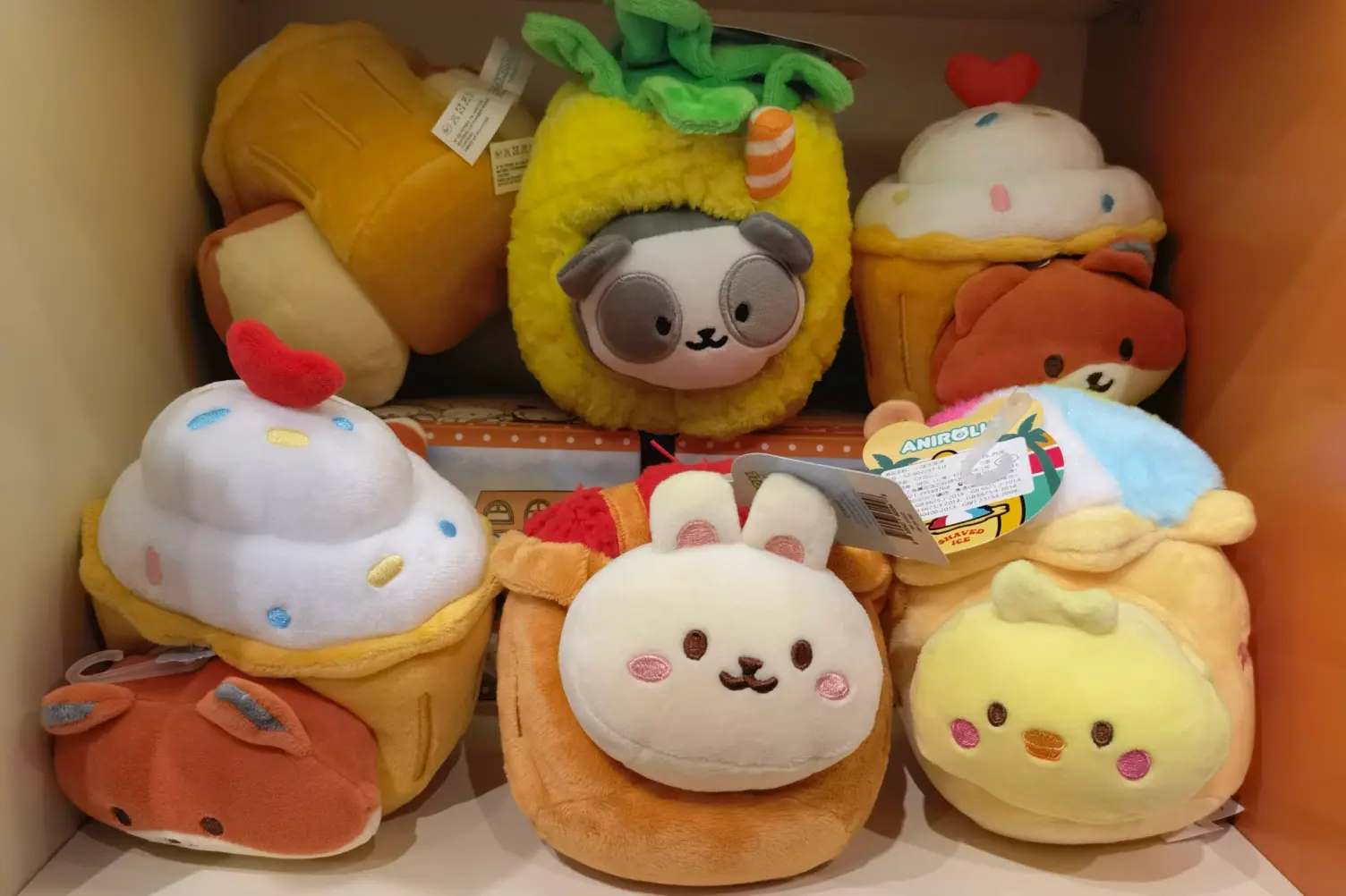 Cartoon plush cushion samples on retail shelf with embroidered faces and tags